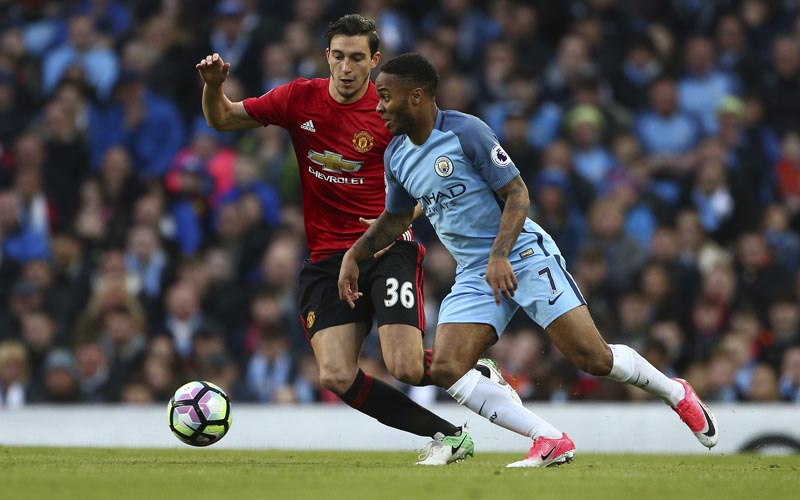 Manchester United's Matteo Darmian, left, and Manchester City's Raheem Sterling challenge for the ball during the English Premier League soccer match between Manchester City and Manchester United at the Etihad Stadium in Manchester, Thursday, April 27, 2017. Photo: AP