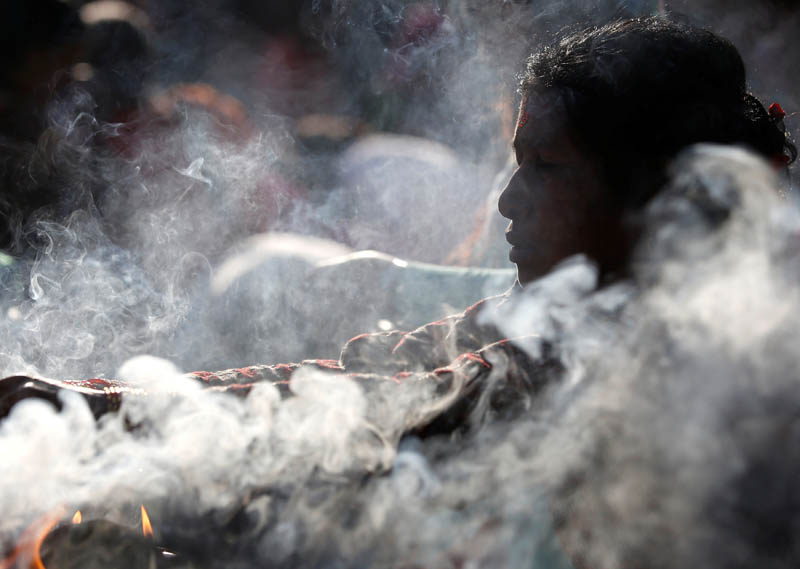 A devotee woman burns incense sticks and lights oil lamp. Photo: Reuters
