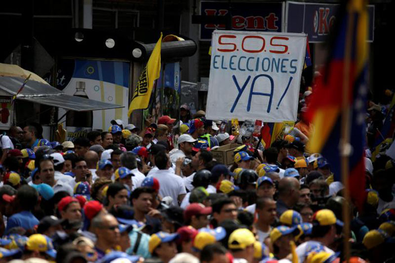 People participate in an opposition rally in Caracas, Venezuela, April 8, 2017. The banner reads: 'S.O.S Elections right now!'. Photo: Reuters