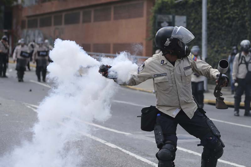 A Bolivarian National Police throw a teargas bomb toward demonstrators during a protest in Caracas, Venezuela, on Saturday, April 8, 2017. Photo: AP