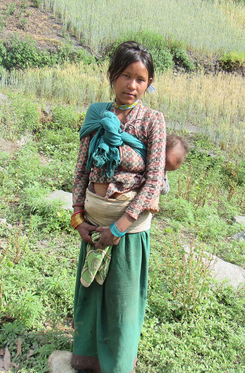 A woman carries her son on her back while returning home empty- handed from Bichchhya Health Post, in Bajura, on Wednesday, May 24, 2017. Photo: THT
