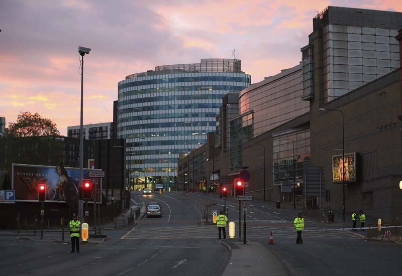 Police stand guard at dawn, after a blast at the Manchester Arena, on Tuesday, May 23, 2017. Photo: Peter Byrne/PA via AP