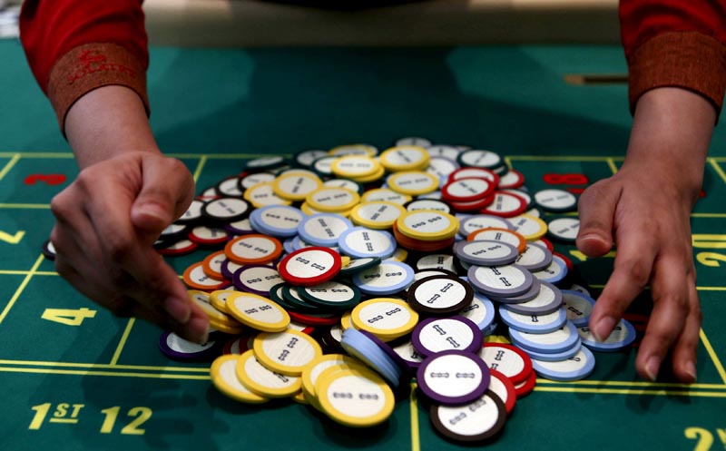 A casino dealer collects chips at a roulette table in Pasay city, Metro Manila, Philippines, on March 27, 2015. Photo: Reuters