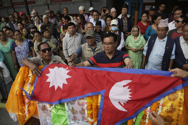 Family members of Nepali climber Min Bahadur Sherchan put Nepalese flag on his deadbody during his funeral in Kathmandu, Nepal, Sunday, May 7, 2017. Photo: AP