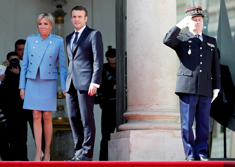 French President Emmanuel Macron and his wife Brigitte Trogneux stand on the steps of the Elysee Palace as former President Francois Hollande (not pictured) leaves after the handover ceremony in Paris, France, May 14, 2017. Photo: AP