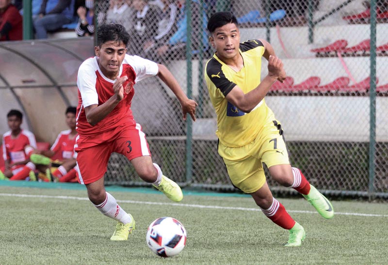 Abhishek Rijal (right) of NPC and Subash  Giri Of brigade Boys Club vie for the ball during their Lalit Memorial U-18 Football Tournament match, in Lalitpur, on Tuesday. photo: THT
