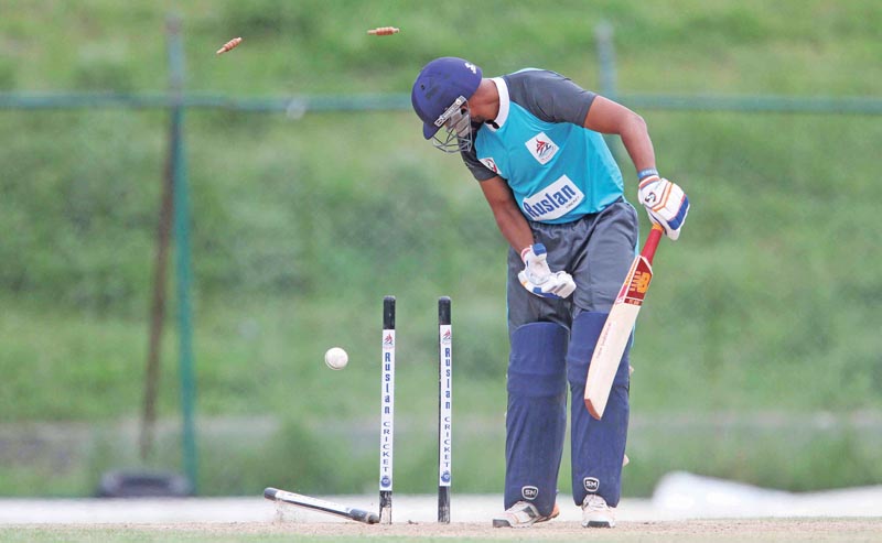 Amar Singh Routela of Mid-western watches his stumps rattled by Kishore Mahato of Central Region during their first Prime Minister Cup One-day National Men's Cricket Tournament match at the TU Stadium, in Kathmandu, on Tuesday. Photo: THT