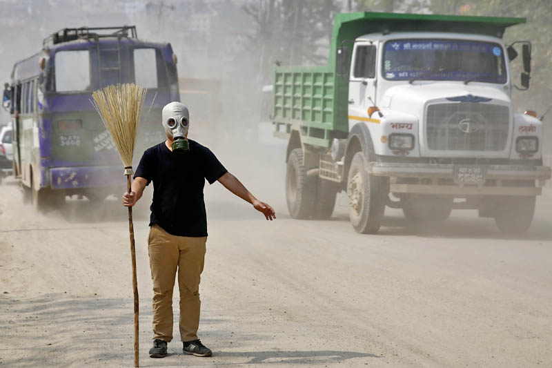 FILE: A man holds a broomstick and wears a gas mask as he stages protest against air pollution on a polluted road in Kathmandu on Sunday, May 07, 2017. Kathmandu ranks among the world's most polluted cities in the world. Photo: Skanda Gautam