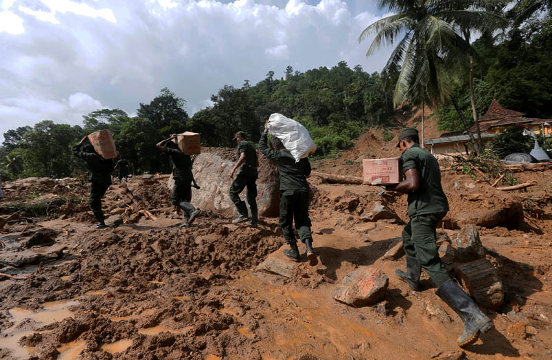 Sri Lankan army soldiers carry food and water for landslide affected people, through the site, during a rescue mission in Athwelthota village, in Kalutara, Sri Lanka May 28, 2017. Photo: Reuters