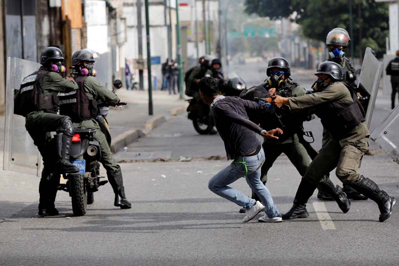 Riot security forces try to detain a demonstrator during a rally called by health care workers and opposition activists against Venezuela's President Nicolas Maduro in Caracas, Venezuela, on May 22, 2017. Photo Reuters