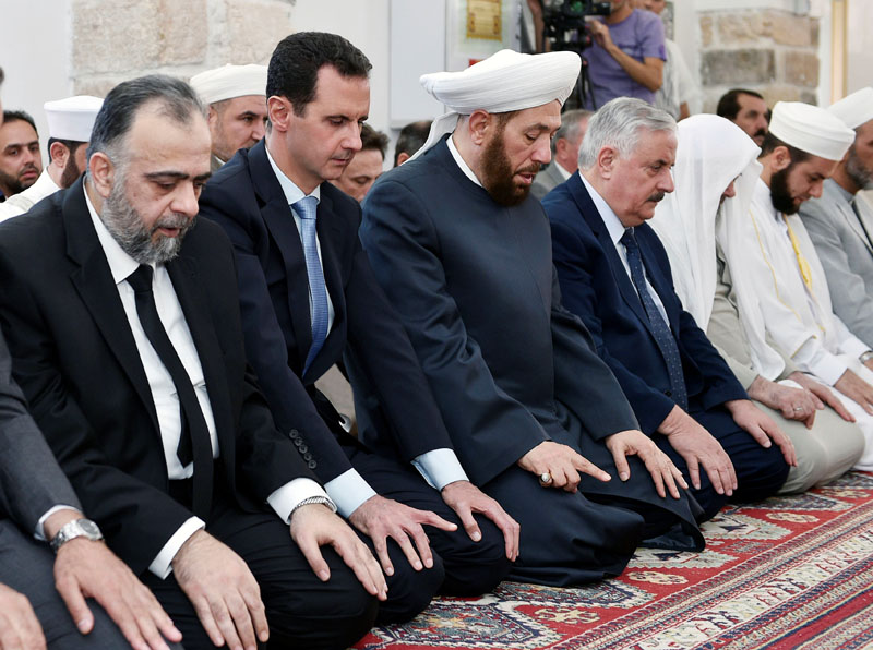 Syria's President Bashar al-Assad (second from left) attends prayers on the first day of the Muslim holiday of Eid al-Fitr, inside a mosque in Hama, in this handout picture provided by SANA on June 25, 2017, Syria. SANA/Handout via REUTERS ATTENTION EDITORS - THIS PICTURE WAS PROVIDED BY A THIRD PARTY. REUTERS IS UNABLE TO INDEPENDENTLY VERIFY THE AUTHENTICITY, CONTENT, LOCATION OR DATE OF THIS IMAGE.
