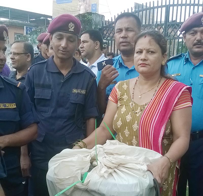 Security personnel guarding an office assistant Laxmi Lamichhane at the Chief Returning Officeru2019s Office Chitwan, while she carries the sealed ballot box from the covered hall in Bharatpur Metropolitan City-10, in Chitwan district, on Tuesday, June 27, 2017. Photo: Tilak Rimal/THT