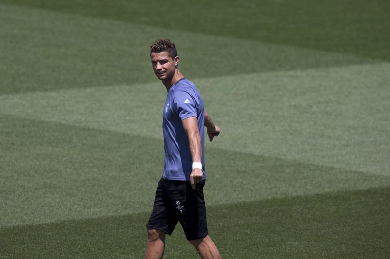 Real Madrid's Cristiano Ronaldo stretches as he enters the field for a training session at a media open day in Madrid, on Tuesday May 30, 2017. Photo: AP
