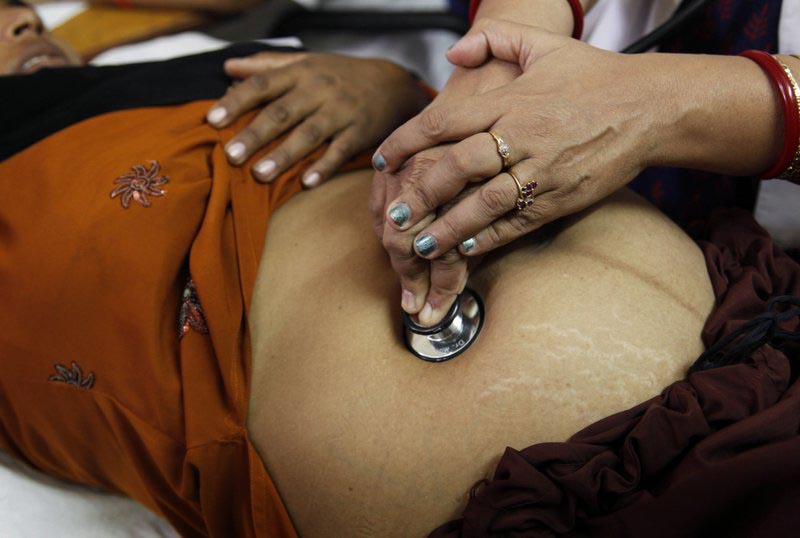 A doctor examines a pregnant woman at the district women's hospital, in Allahabad, in Indiau0092s most populous state of Uttar Pradesh, on October 22, 2011. Photo: AP/ File