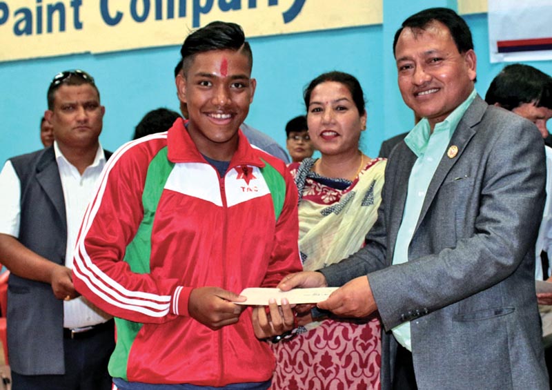 Olympian swimmer Sirish Gurung receives rewards from NSC Member Secretary Keshab Kumar Bista in Lalitpur. Photo: THT