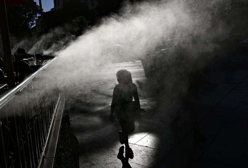 In this June 16, 2017, photo, a girl walks through a mister during the start of a heat wave in Las Vegas. Photo: AP