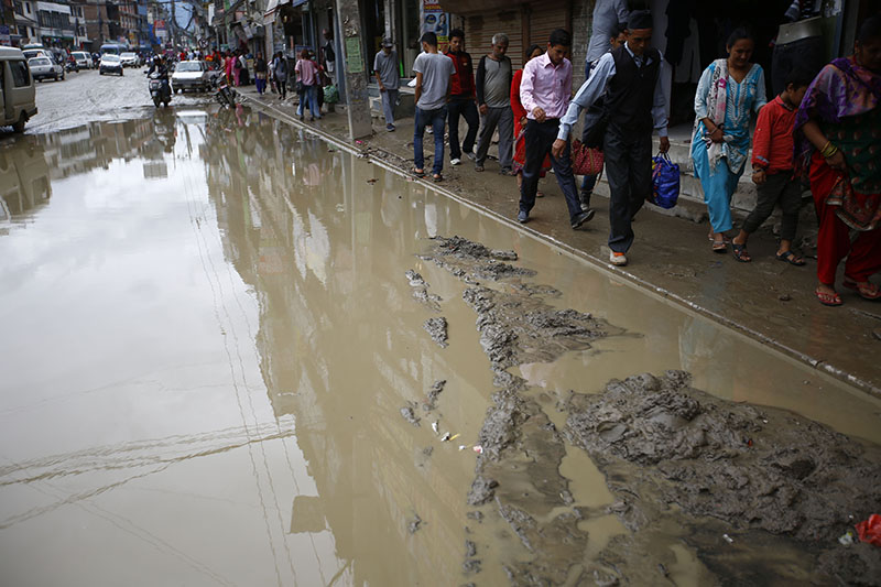 Pedestrians walk aside a waterlogged muddy road in Chabahil, Kathmandu on Friday, July 21, 2017. Photo: Skanda Gautam/THT
