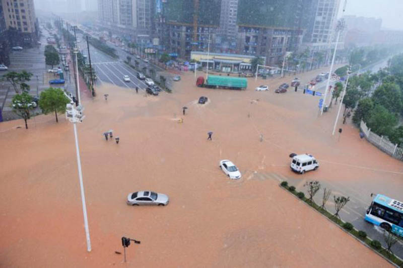 Pedestrians and vehicles cross a flooded street during heavy rain in Changsha, Hunan province, China, July 1, 2017. Photo: CNS/Yang Huafeng via REUTERS