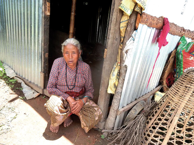 Purni Tamang, whose house was damaged in the 2015 earthquakes, sitting in front of a hut, in Dolakha, on Saturday, July 15, 2017. Photo: THT