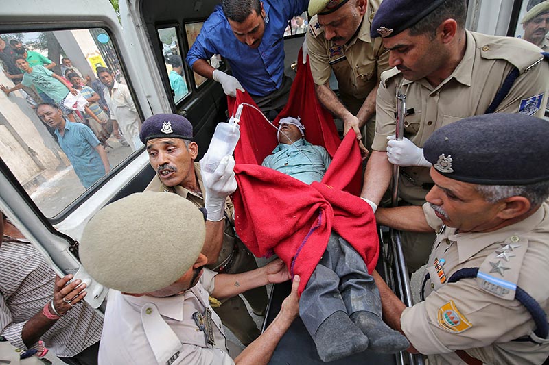 A man who was injured after a bus he was travelling in skidded off a mountain road and fell into a gorge in Jammu and Kashmiru2019s Ramban district, is rushed to a hospital for treatment in Jammu, on July 16, 2017. Photo: Reuters