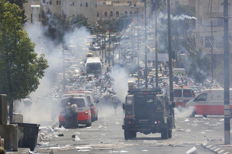 Palestinians run away from tear gas shot by Israeli army during clashes in the West Bank city of Bethlehem, on Friday, July 21, 2017. Photo: AP