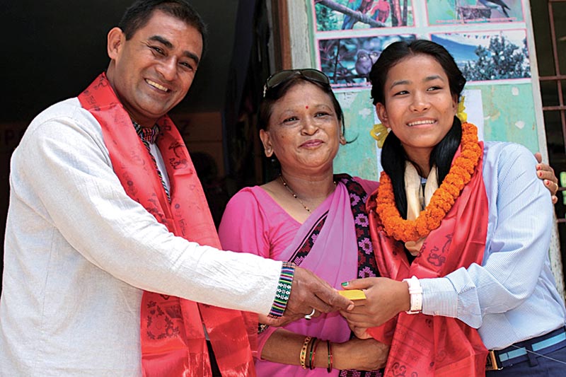 Joint General Secretary of Nepal Judo Association Surya Shrestha handing over cash to Manita Shrestha Pradhan at a felicitation programme organised by Bal Bikash School on Monday. Photo: THT