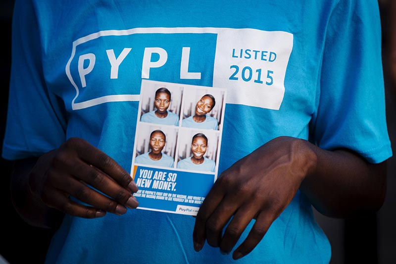A Paypal employee holds photographs of herself during celebrations for the company's relisting on the Nasdaq in New York, on July 20, 2015. Photo: Reuters/ File
