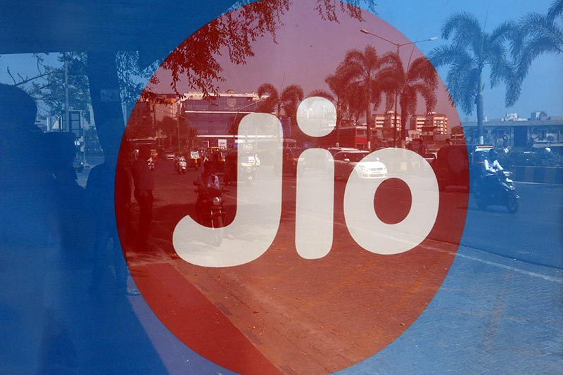 Commuters are reflected on an advertisement of Reliance Industries' Jio telecoms unit, at a bus stop in Mumbai, India, on February 21, 2017. Photo: Reuters/ File