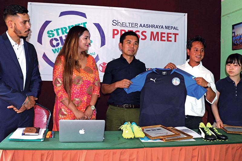 Former Nepal national team footballer Basanta Gauchan and President of Funroots Academy Jun Hirano (centre) displaying the jersey before handing over to the children of Shelter Aashraya Nepal as others look on, at a press meet in Kathmandu on Monday. Photo: THT