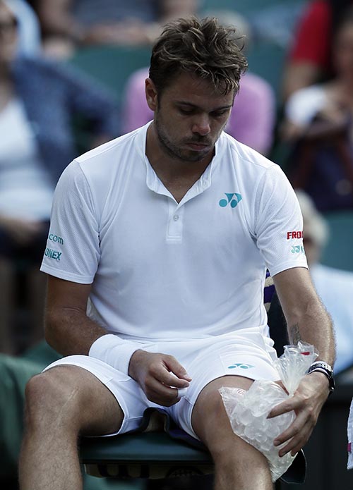 Switzerland's Stan Wawrinka ices his knee during a break in his Men's Singles Match against Russia's Daniil Medvedev, on the opening day at the Wimbledon Tennis Championships in London, on Monday, July 3, 2017.