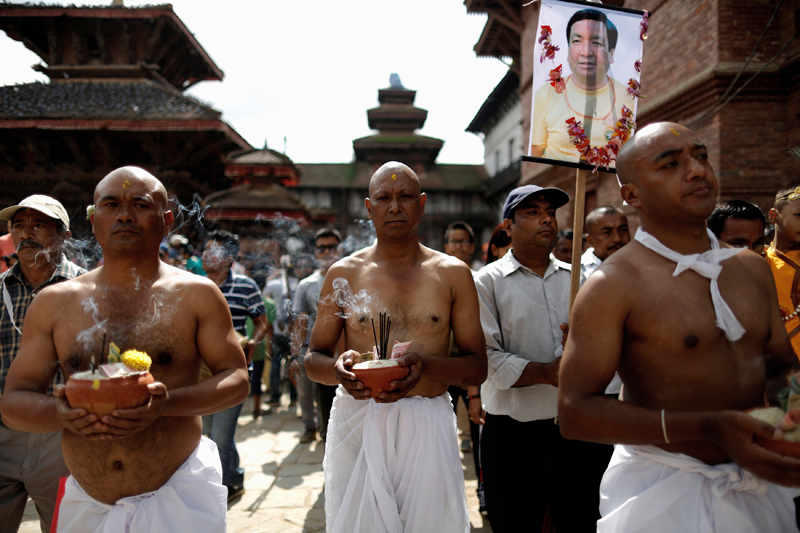 Family members, along with the portrait of a departed loved one, participate in a parade to mark the Gaijatra Festival, also known as the festival of cows, in Kathmandu, August 8, 2017. Photo: Reuters
