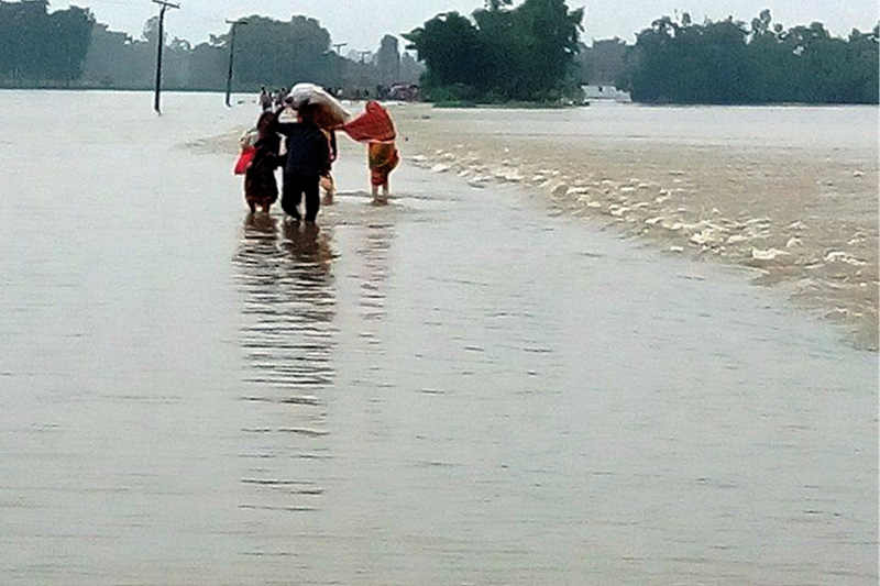 Locals walk along the road that fllod has turned into river, in Rautahat, on Saturday, August 12, 2017. Photo: Prabhat Jha