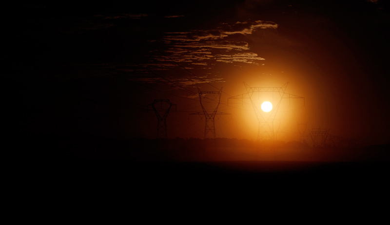 The sun rises behind pylons of high-tension electricity power lines outside Longnes, near Paris, France, August 6, 2017. Photo: Reuters