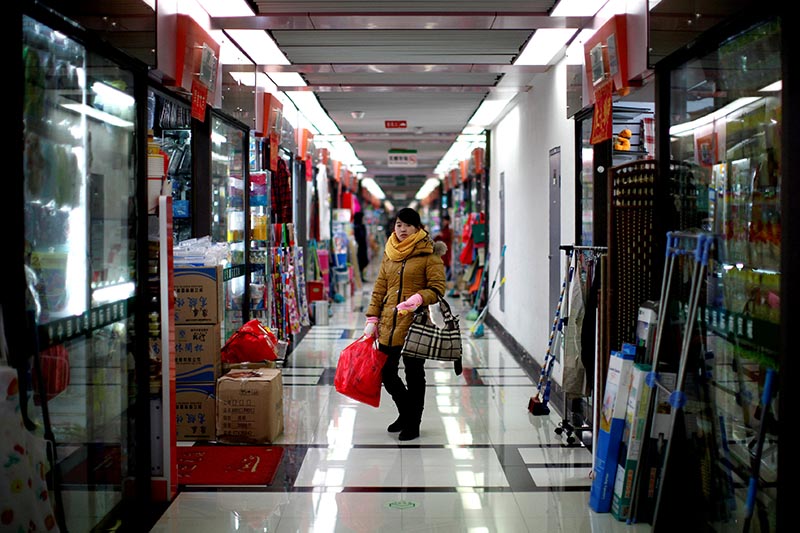 A woman pauses as she shops at a wholesale market in Yiwu, Zhejiang province, on January 11, 2011. Photo: Reuters