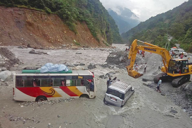 An excavator being used to pull vehicles stuck in a flooded Begkhola rivulet along Beni-Jomsom road section in Myagdi district, on Saturday, September 2, 2017. Photo: RSS