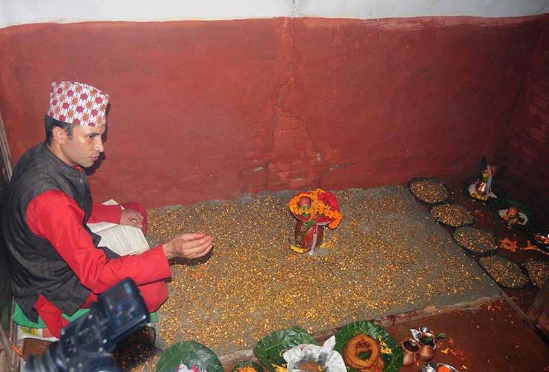 FILE - A priest sow barley seeds to grow jamara, the saplings which would be taken as the prasad of Goddess Durga, on the occasion of Gatasthapana, the first day of 15-day Badadashain festival, at Hanumandhoka, in Kathmandu, on Thursday, September 21, 2017. Photo: Balkrishna Thapa Chhetri