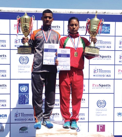 Nepal APF Club athlete Gopi  Chand Parki and Tribhuvan Army Club's Sarita Basi Hold The trophies after winning the Kathmandu marathon, in Kathmandu, on Saturday. Photo: THT