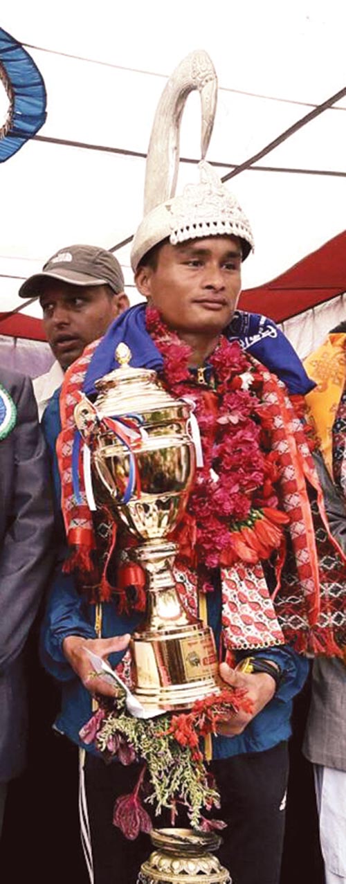 TACu2019s Khagendra Bahadur Bhat holds the trophy after winning the Liglige Race in Gorkha on Monday. Photo: THT