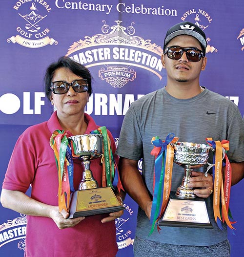 Gross category winner Phuntsok N Lama and womenu2019s section champion Kalpana Limbu hold their trophies after the Master Selection Golf Tournament organised by Vijay Distillery at the Royal Nepal Golf Club in Kathmandu on Saturday. Photo: THT