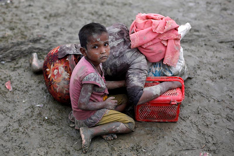 A Rohingya refugee girl sits next to her mother who rests after crossing the Bangladesh-Myanmar border, in Teknaf, Bangladesh, on September 6, 2017. Photo: Reuters