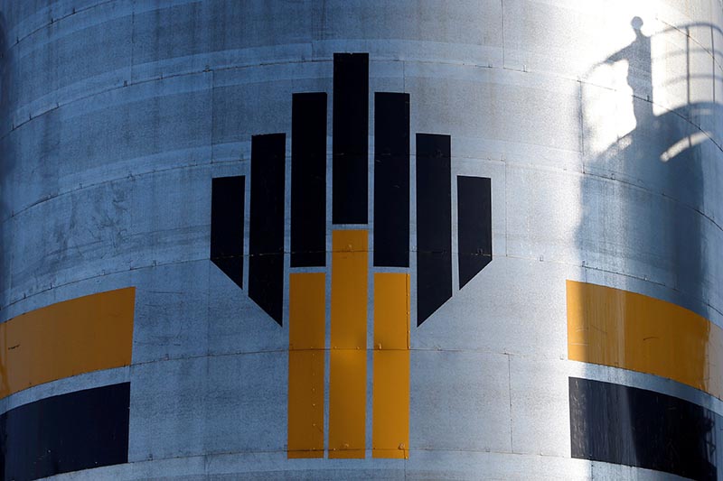 The shadow of a worker is seen next to a logo of Russia's Rosneft oil company at the central processing facility of the Rosneft-owned Priobskoye oil field outside the West Siberian city of Nefteyugansk, Russia, on August 4, 2016. Photo: Reuters/ File