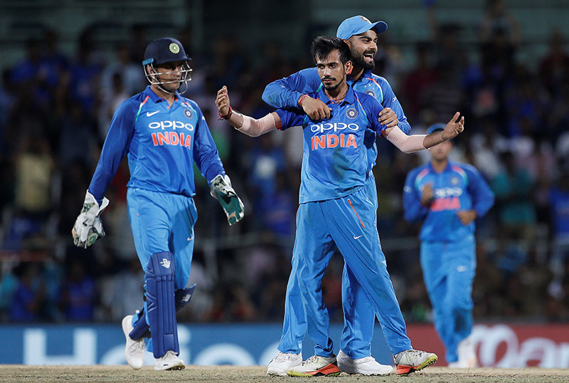 Yuzvendra Chahal, team's captain Virat Kohli and Mahendra Singh Dhoni of India celebrate the dismissal of Glenn Maxwell of Australia. Photo: Reuters