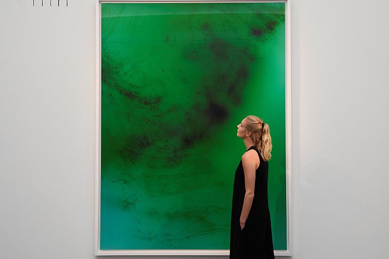 An employee poses next to 'Frieschwimmer 193' by Wolfgang Tillmans, at Sotheby's in London, Britain, on October 12, 2017. Photo: Reuters
