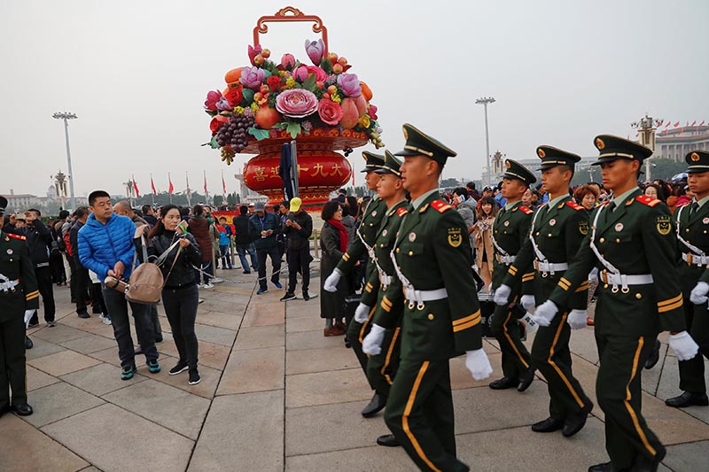 Paramilitary policemen march as people attend a flag-raising ceremony at Tiananmen Square a day before the 19th National Congress of the Communist Party of China begins in Beijing, China, on October 17, 2017. Photo: Reuters