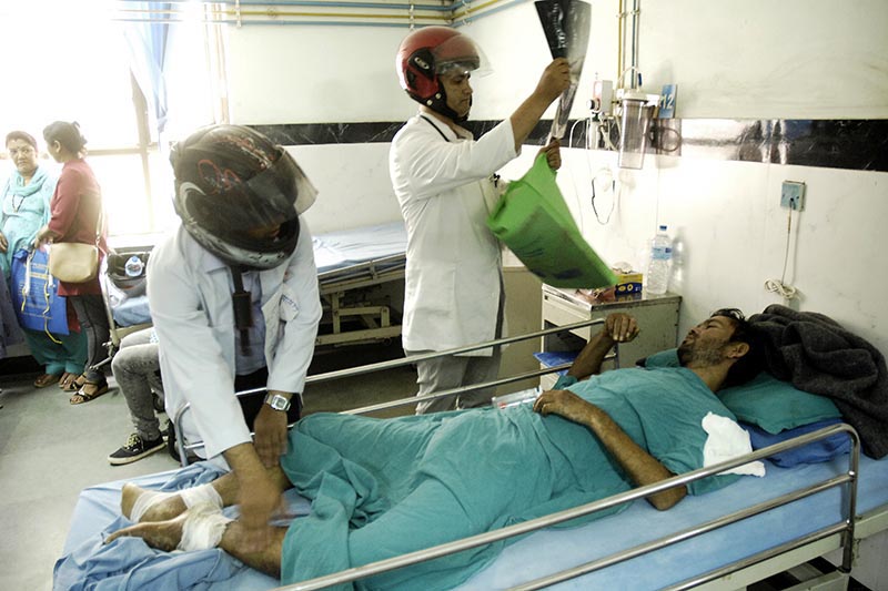 Doctors wearing helmets examine a patient at National Trauma Centre, Kathmandu, on Wednesday, October 4, 2017. Photo: THT.