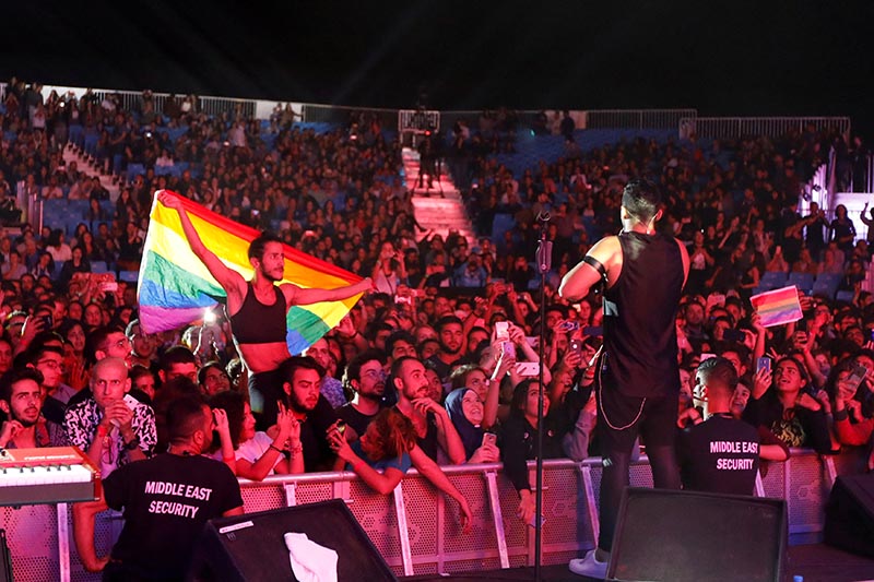 A fan of Lebanese alternative rock band Mashrou' Leila holds a rainbow flag during their concert at the Ehdeniyat International Festival in Ehden town, Lebanon, on August 12, 2017. Photo: Reuters/ File