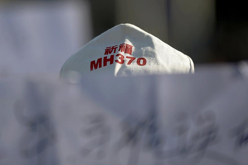 A family member of a passenger onboard Malaysia Airlines flight MH370 which went missing in 2014 holds a banner during a gathering in front of the Malaysian Embassy on the second anniversary of the disappearance of MH370, in Beijing, China, on March 8, 2016.  Photo: Reuters/ File