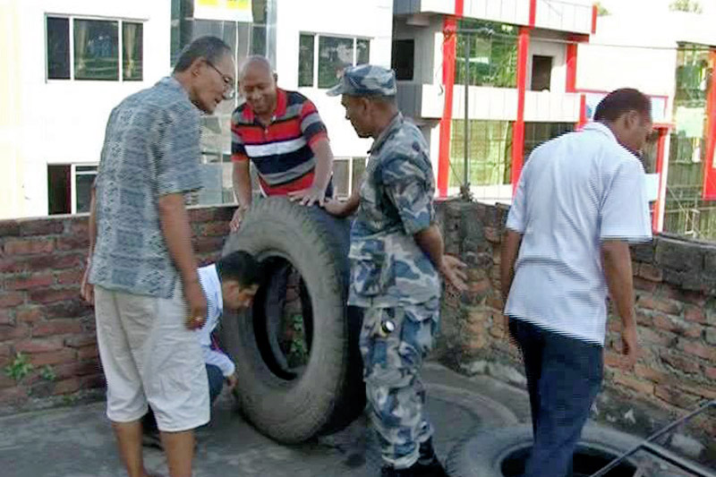 Health officials checking mosquito breedings in a  tyre in Dhadingbesi of Dhading district, on Wednesday, October 4, 2017. Photo: Keshav Adhikari