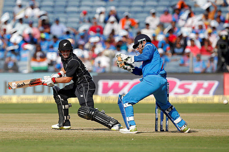 New Zealand's Tom Latham (L) plays a shot as India's wicketkeeper Mahendra Singh Dhoni looks on. Photo: Reuters