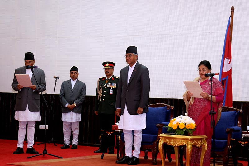 President Bidhya Devi Bhandari (left) administering the oath of office and secrecy to newly appointed Deputy Prime Minister Kamal Thapa (right), in the presence of Prime Minister Sher Bahadur Deuba (centre), in Shital Niwas, Kathmandu, on Saturday 14, 2017. Photo: RSS